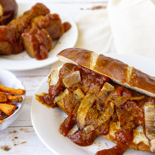 Easy Vegan Currywurst on a white plate with sweet potato fries on the side