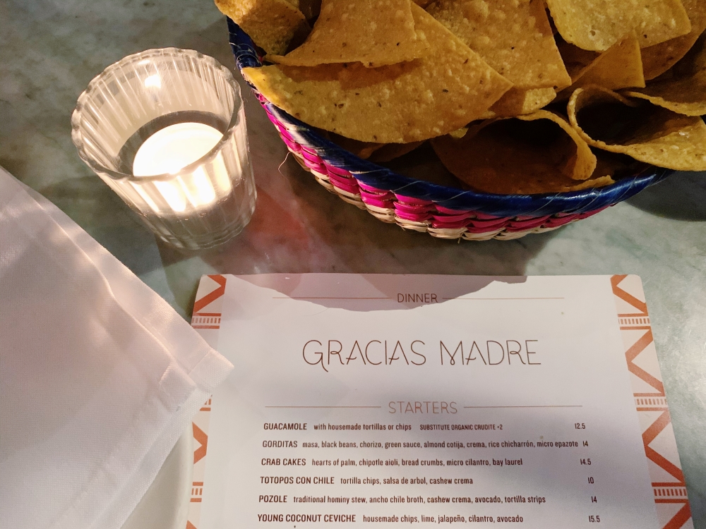 Gracias Madre menu with chips and a candle in the background