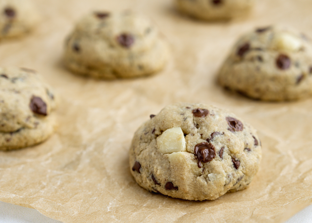 Closeup of macadamia nut cookies on a brown baking sheet