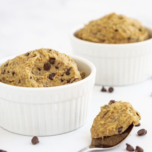 Chickpea cookie dough in two bowls and on a spoon in a white background