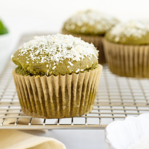 Three green juice pulp muffins on a cooling rack